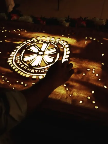 The Rotary International logo, drawn in sand during a live event for the Rotary Club of Muzaffarnagar. Creating precise and recognizable logos is a key skill for corporate and organizational events, ensuring the brand is the hero of the story.