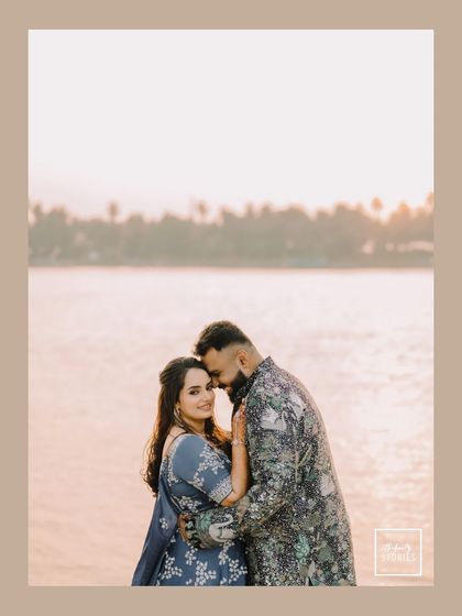 A romantic portrait set against the soft light of sunset by the water. This image from a Sangeet shoot captures a quiet, intimate moment amidst the celebration.