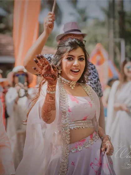 The bride making her entrance for the Mehendi ceremony. Her happy wave and beautiful lehenga set the tone for a wonderful celebration ahead.