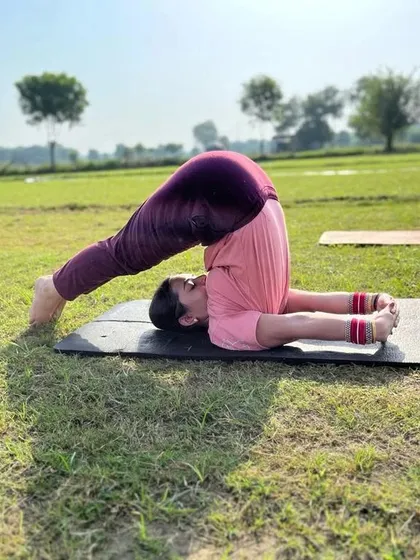 Practicing Halasana, or Plow Pose, in the fresh air. The open space adds a feeling of freedom to the practice.