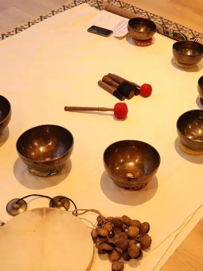 An overhead view of the instruments used in a sound bath, including a frame drum and seed shakers. The variety of natural sounds helps create a layered, immersive experience that promotes deep relaxation.