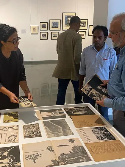 The artist and curator discussing the layout of the archival vitrine.