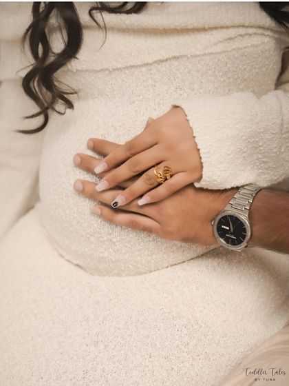 United in love. Another beautiful detail shot of the couple's hands together on the bump, a simple and powerful symbol of their shared journey into parenthood.