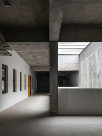 A view of the raw, board-formed concrete corridors at the Manipal School of Architecture and Planning (MSAP). The design emphasizes the structural honesty of the materials.