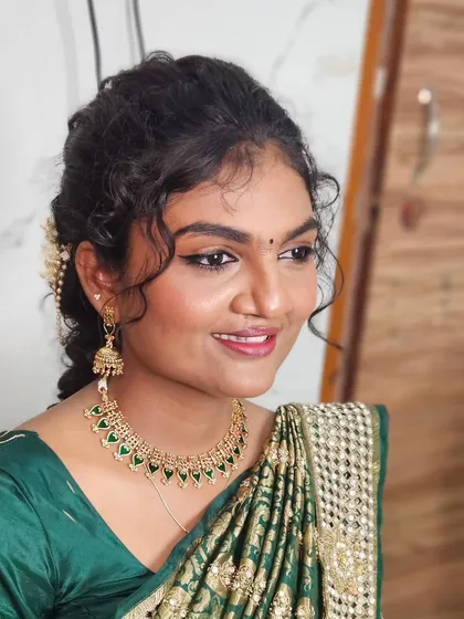 A beautiful look with a green saree and curly hair, perfect for a party or pre-wedding event.