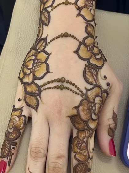 A classic Arabic shading design. The floral vine flows diagonally across the hand, with shaded petals that give it depth.