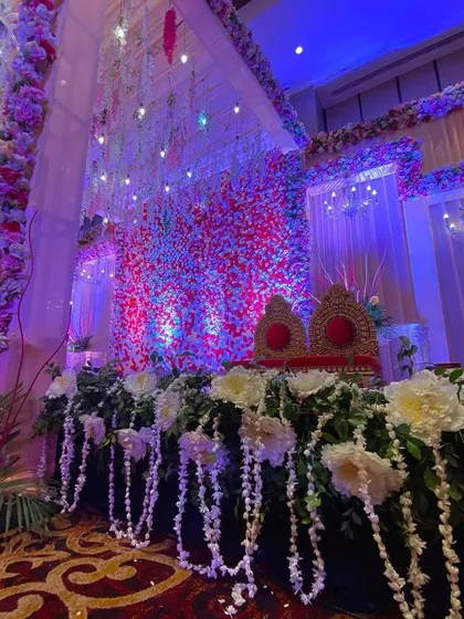 A side view of the indoor floral stage, highlighting the lush greenery and hanging flower details.