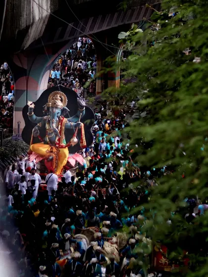 A glimpse of the idol through an archway, surrounded by a dense crowd, capturing the feeling of being in the middle of the festivities.
