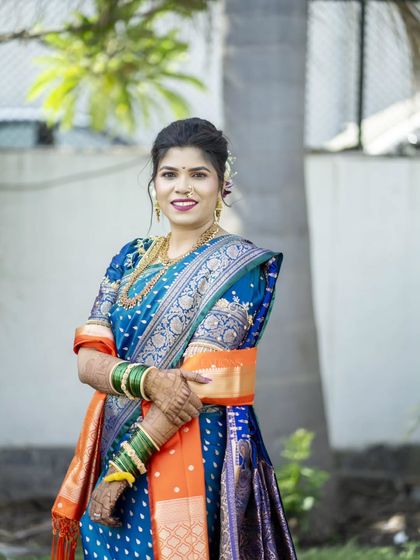 A classic bridal portrait, capturing her confident smile and the richness of her traditional attire.