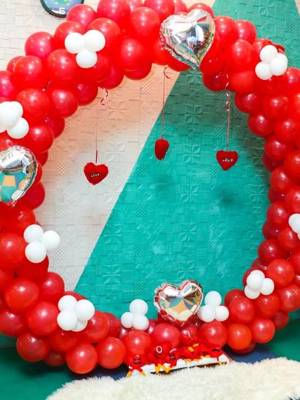 A heart-themed balloon wreath in red and white. This setup is perfect for adding a touch of love to any celebration and serves as a wonderful photo backdrop.