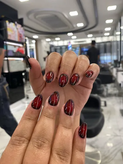 A close-up of the Korean airbrush technique, showing a deep red blending into black with a fine white outline for a dramatic 3D effect.