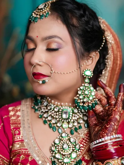 A close-up shot focusing on the eye makeup and the beautiful contrast between the green jewelry and the red outfit.