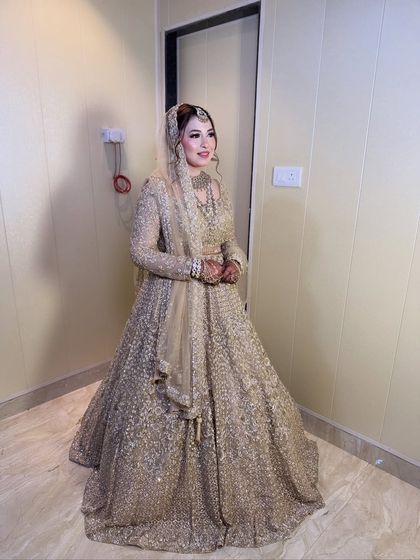 Another full-length view of the bride's stunning gold Walima outfit. The entire look is the epitome of reception glamour.
