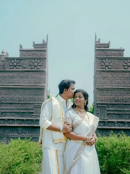 A tender forehead kiss against a majestic backdrop. This photo of Aditya and Priyanka in traditional outfits is both grand and deeply romantic.