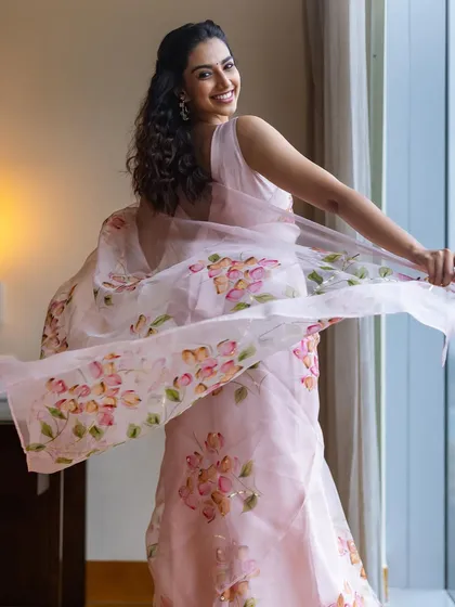 A playful, candid moment captured in the pink floral organza saree. I love directing these "in-between" moments to show the personality behind the fashion.