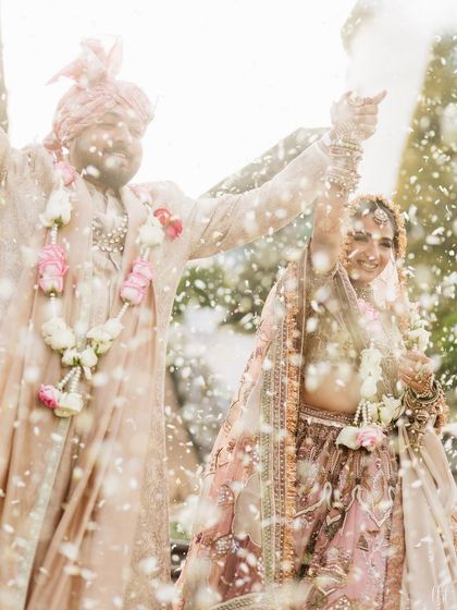 A celebratory moment filled with joy and flower petals. Vasav's radiant look shines through, a testament to a happy bride.
