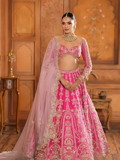 A full-length portrait of the bride in her magnificent pink lehenga. The entire look is a perfect blend of modern color and traditional elegance.