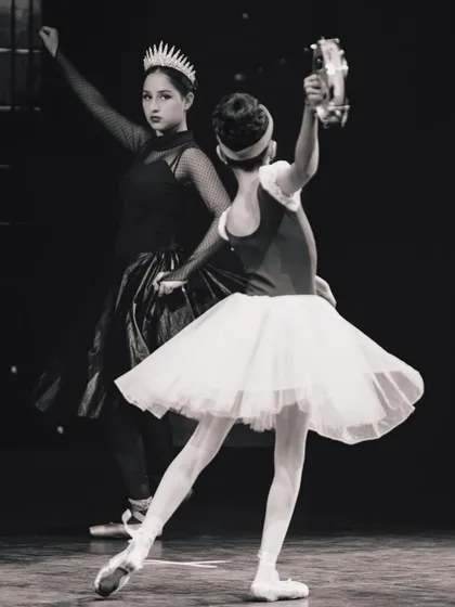 A black and white capture of the drama on stage. The contrast between the Evil Queen and Snow White highlights the storytelling we weave into our ballet productions.