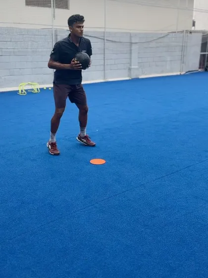 A tennis player holding a medicine ball, demonstrating the closed stance deceleration needed for stability after a lateral sprint. This is vital for maintaining balance and preparing for the next shot.
