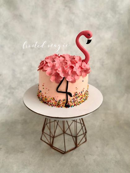 A pretty flamingo cake perfect for a summer party. This is a buttercream cake decorated with sprinkles, sugar hydrangeas, and a simple, elegant fondant flamingo topper.