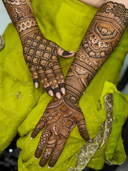 A beautiful bridal design with a mix of classic elements. You can see peacocks, lotuses, and wedding bells woven into a dense pattern that extends from the fingertips to the elbows.