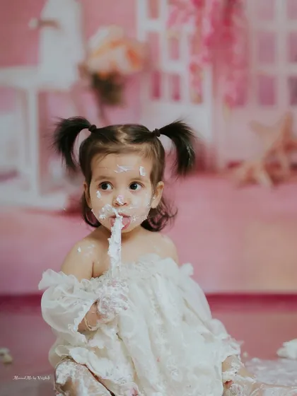 A sweet and messy portrait. Her pigtails and frosting-covered fingers make this an absolutely adorable shot.
