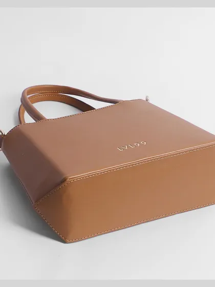 The bottom view of a tan handbag, showing its sturdy base and construction. We capture all details, big and small.
