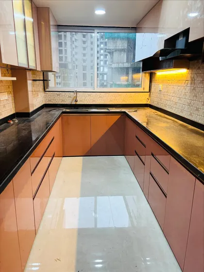 This U-shaped kitchen layout maximizes counter space and storage. The glossy pink laminate is used on all base cabinets for a consistent and modern look.