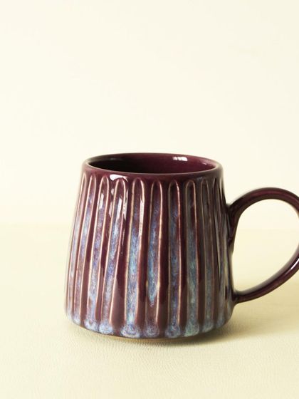 This scooped dripping mug has a deep, lustrous aubergine glaze that catches the light beautifully. The vertical texture adds a modern yet rustic feel to your coffee routine.