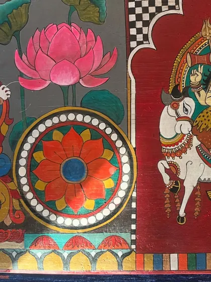 A detail shot focusing on the side panel, where a lotus motif and a depiction of Surya on his chariot add layers to the trunk's story. These elements are drawn from traditional temple carvings and paintings.