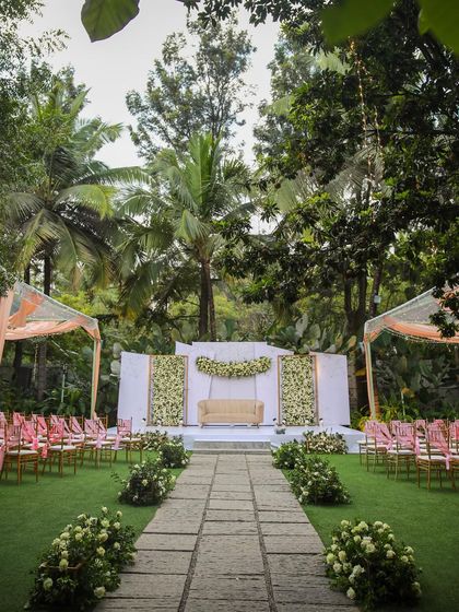 A collection of stunning wedding setups at The Farmhouse Collective. You can see the venue's versatility, from elegant morning ceremonies with floral mandaps to glamorous evening receptions with fairy lights and chic decor. This space is a blank canvas for your dream outdoor wedding in Bengaluru.
