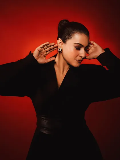 A soft, elegant pose that showcases the voluminous sleeves and the sleek bun hairstyle.