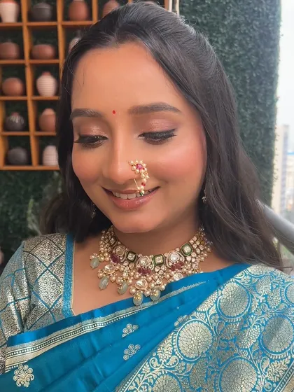 A close-up with eyes looking down, this image highlights the subtle shimmer on the eyelids and the flawless base. It's a look that is both elegant and understated.