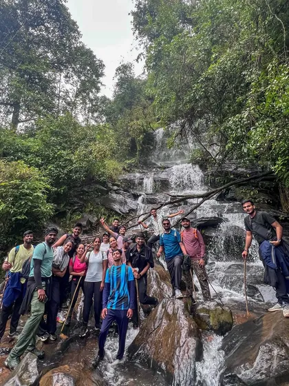 Our happy group posing in front of a multi-tiered waterfall on the Netravathi trek. It's a perfect spot to rest and take photos.