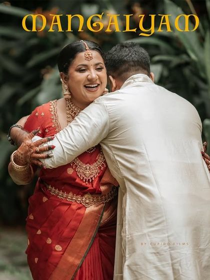 The word "Mangalyam" overlays a heartfelt hug between Aiswarya and Jhon, symbolizing the sacred bond of their interfaith marriage in Kochi.