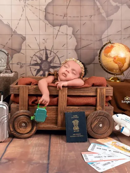 A sleepy traveler dreaming of her next destination. The vintage map, airplane, and travel documents create a rich and detailed backdrop for this newborn portrait.