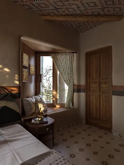 The play of natural light through the window creates a serene and contemplative mood in this corner of the room. The simple, rustic wooden door and side table complement the patterned floor tiles.
