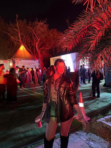 The red lighting at the concert adds a dramatic effect to my edgy outfit.