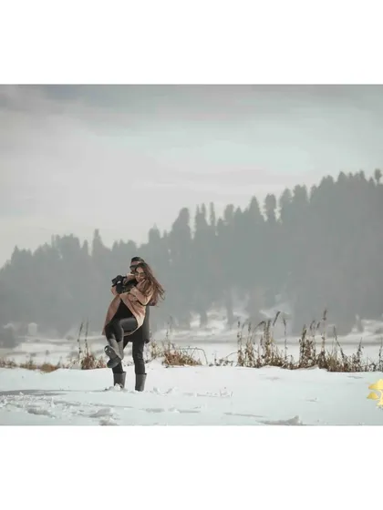 A joyful lift in the snow. This photo perfectly captures the couple's happiness and the magical feeling of their Kashmir pre-wedding adventure.