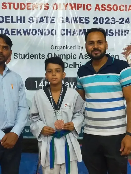 Our junior athlete with his medal at the Students Olympic Delhi State Championship.
