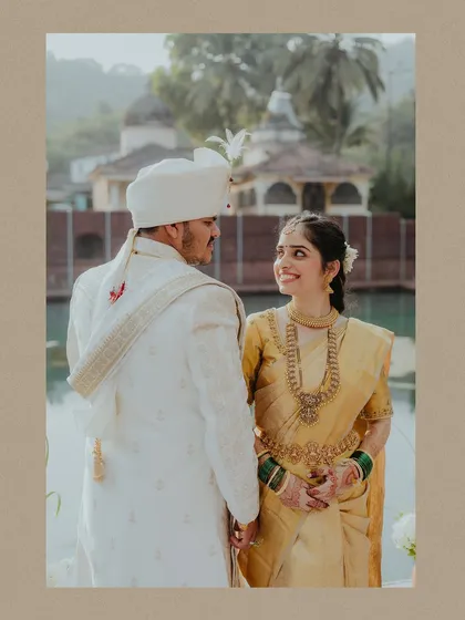 A sweet portrait of a Konkani couple in Goa, sharing a look of love in their traditional wedding attire.