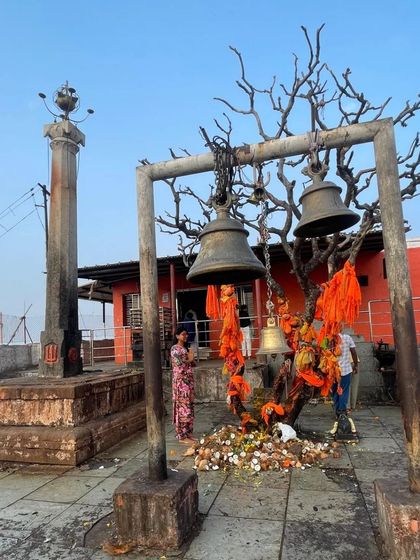 A view of a hilltop temple in Hampi, adorned with prayer flags.