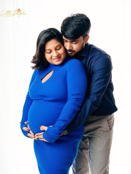A tender embrace from behind, a pose that beautifully showcases the baby bump and the protective love of the partner.