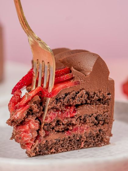 A close-up of a slice of our Strawberry Ganache Cake, showing the rich texture of the ganache and the fresh fruit layers.