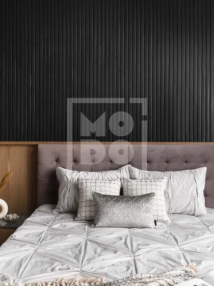 We used a dramatic black fluted panel wall as a headboard in this bedroom. The contrast with the warm wood and soft grey bedding creates a bold yet cozy and relaxing atmosphere.