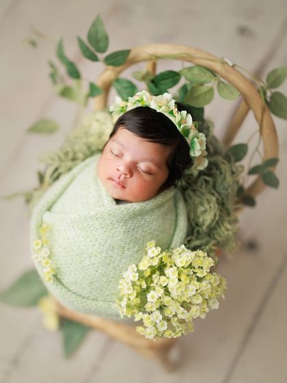 Pista perfection. The soft green of the wrap and floral crown, combined with leafy green accents, creates a fresh, nature-inspired look.