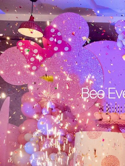 A sparkling celebration moment at a Minnie Mouse-themed party. The combination of sparklers and confetti creates a dazzling effect, making the cake-cutting ceremony truly special.