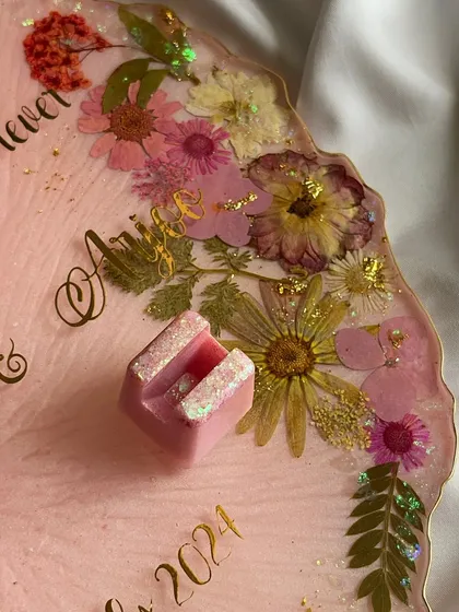 The custom ring holders, sparkling with a touch of glitter, are designed to hold the rings securely while adding to the platter's beauty.