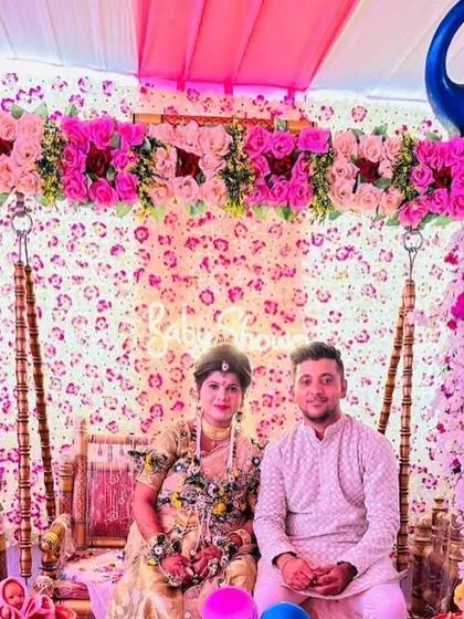 The happy couple posing on the decorated swing at their baby shower, showcasing a beautiful moment created by my decor.