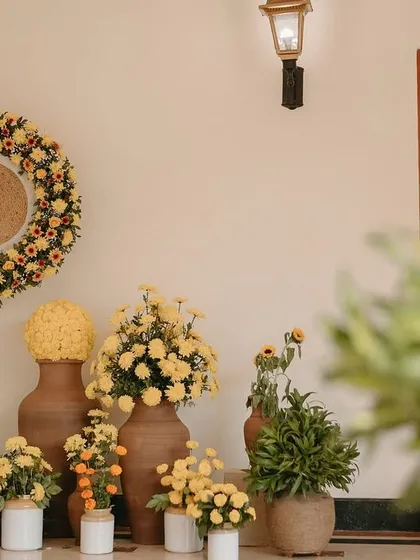 A corner arrangement showing the variety of pots and floral arrangements used to create a cohesive Haldi decor theme.